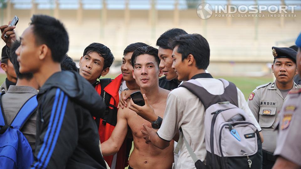 Kim Kurniawan dari PBR melayani permintaan berfoto dari para pendukung PBR setelah berhasil menang atas Persita dan lolos  pada babak delapan besar di stadion Singaperbangsa, Karawang, Jumat (05/09/14).